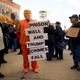 A protester dressed as President Donald Trump holds a placard stating ‘PRISON WALL AND TRUMP CRIMES FALL’ while demonstrating with Philadelphia Airport TSA and airport workers outside the Philadelphia International Airport on January 25, 2019 in Philadelphia, Pennsylvania. The government shutdown, now lasting 35 days, is the longest in United States history, affecting about 800,000 federal employees.